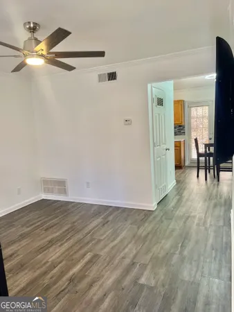 a view of a room with wooden floor table and chairs