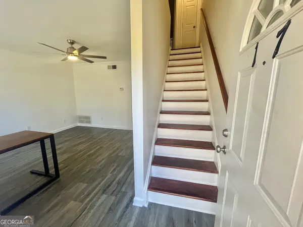 a view of a hallway with wooden floor and staircase