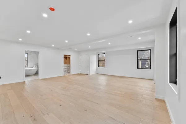 a view of an empty room with a window and a ceiling fan