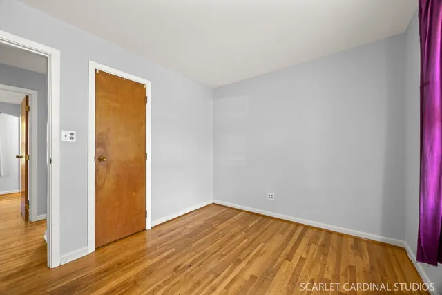 a view of empty room with wooden floor and wooden floor