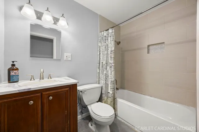 a bathroom with a sink a toilet a mirror a vanity and bathtub