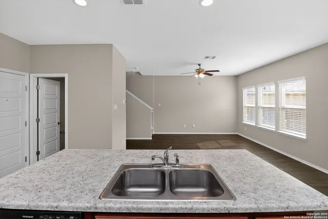 a kitchen with a sink granite counter tops and a stove