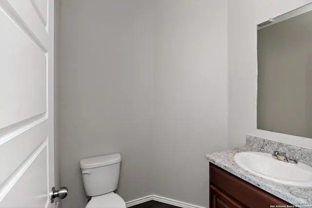 a bathroom with a granite countertop toilet and sink