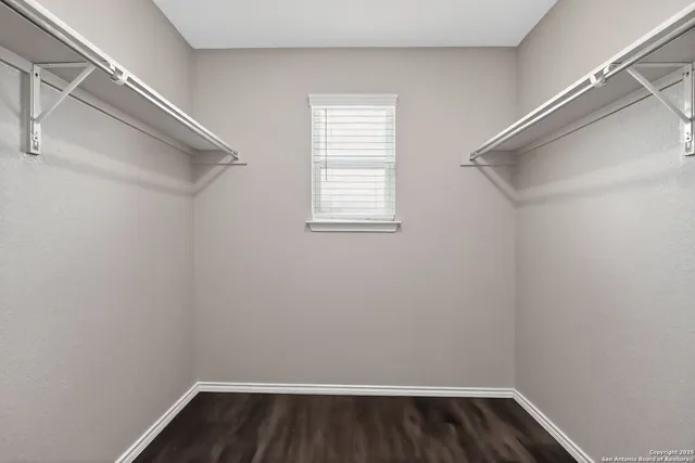 a view of a room with wooden floor and small window