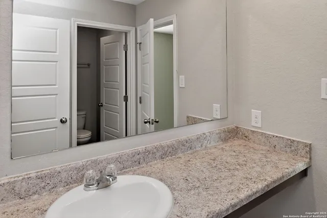 a bathroom with a granite countertop sink and a mirror