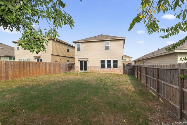 a view of a backyard with wooden fence