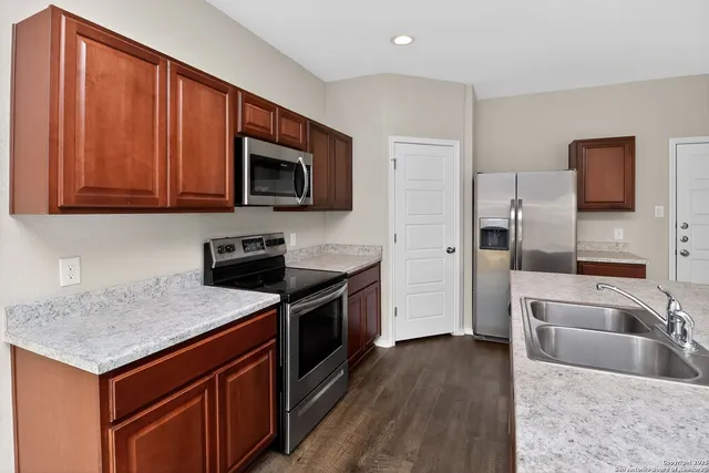 a kitchen with stainless steel appliances granite countertop a sink stove and refrigerator