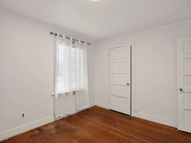an empty room with fireplace and windows