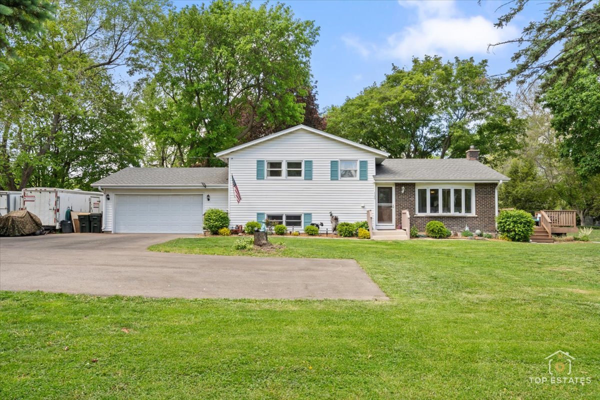 120-3 Three Oaks Road Cary, IL 60013 - Photo 1 of 28 a front view of a house with a yard and garage