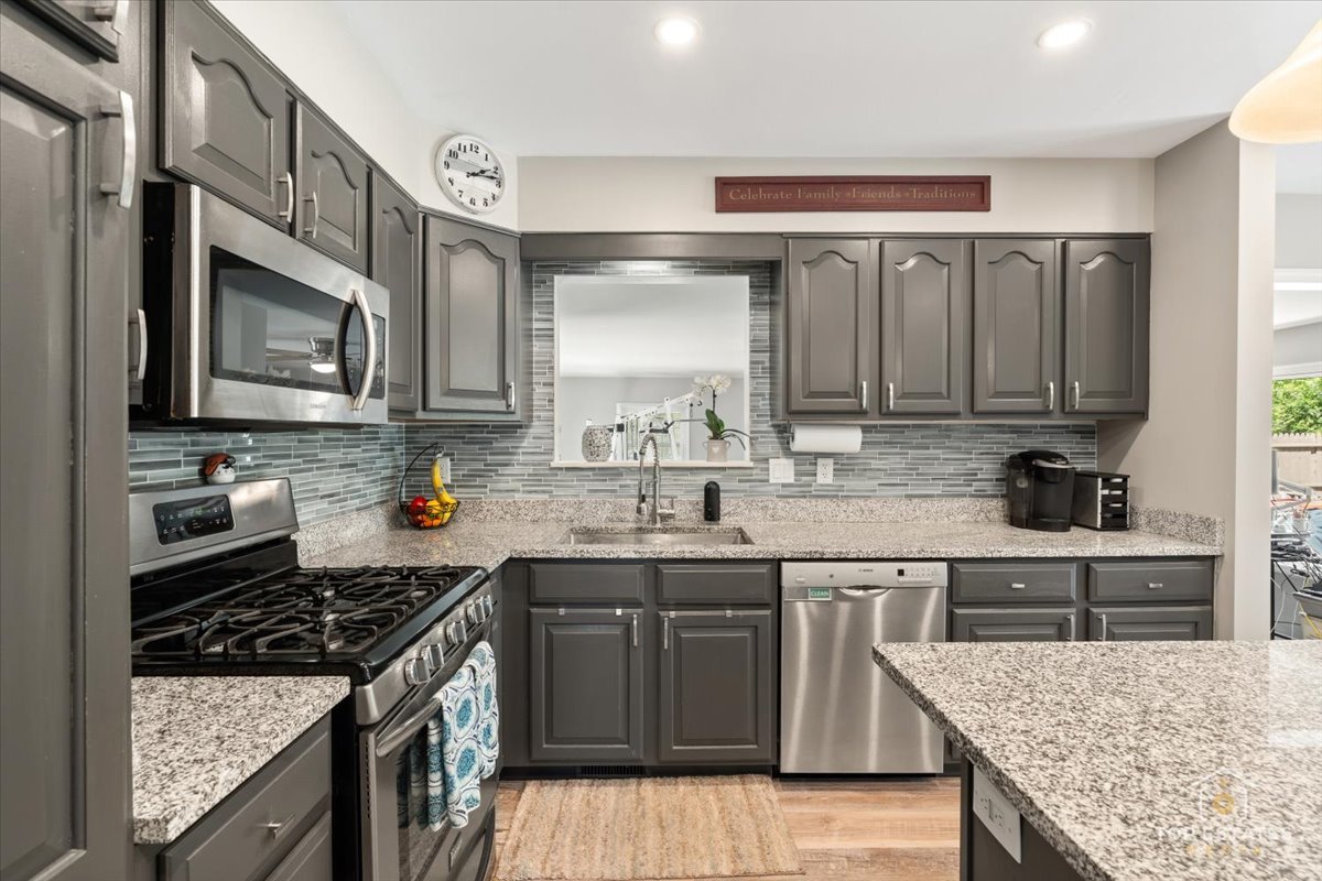 120-3 Three Oaks Road Cary, IL 60013 - Photo 11 of 28 a kitchen with stainless steel appliances granite countertop a stove top oven a sink a counter space and cabinets