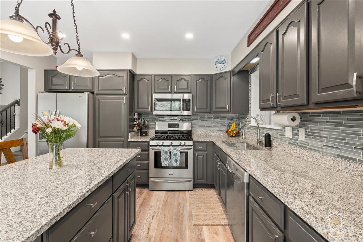 120-3 Three Oaks Road Cary, IL 60013 - Photo 12 of 28 a kitchen with stainless steel appliances granite countertop a sink stove and refrigerator