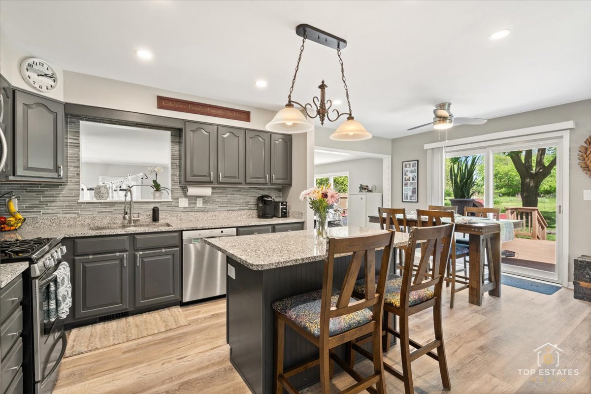 120-3 Three Oaks Road Cary, IL 60013 - Photo 10 of 28 a kitchen with stainless steel appliances granite countertop wooden cabinets a stove a sink a dining table and chairs