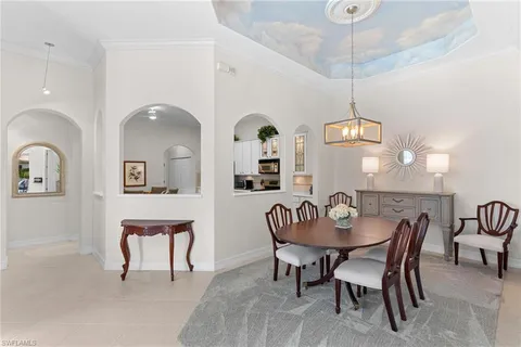 a kitchen with a refrigerator a stove a sink cabinets and a dining table