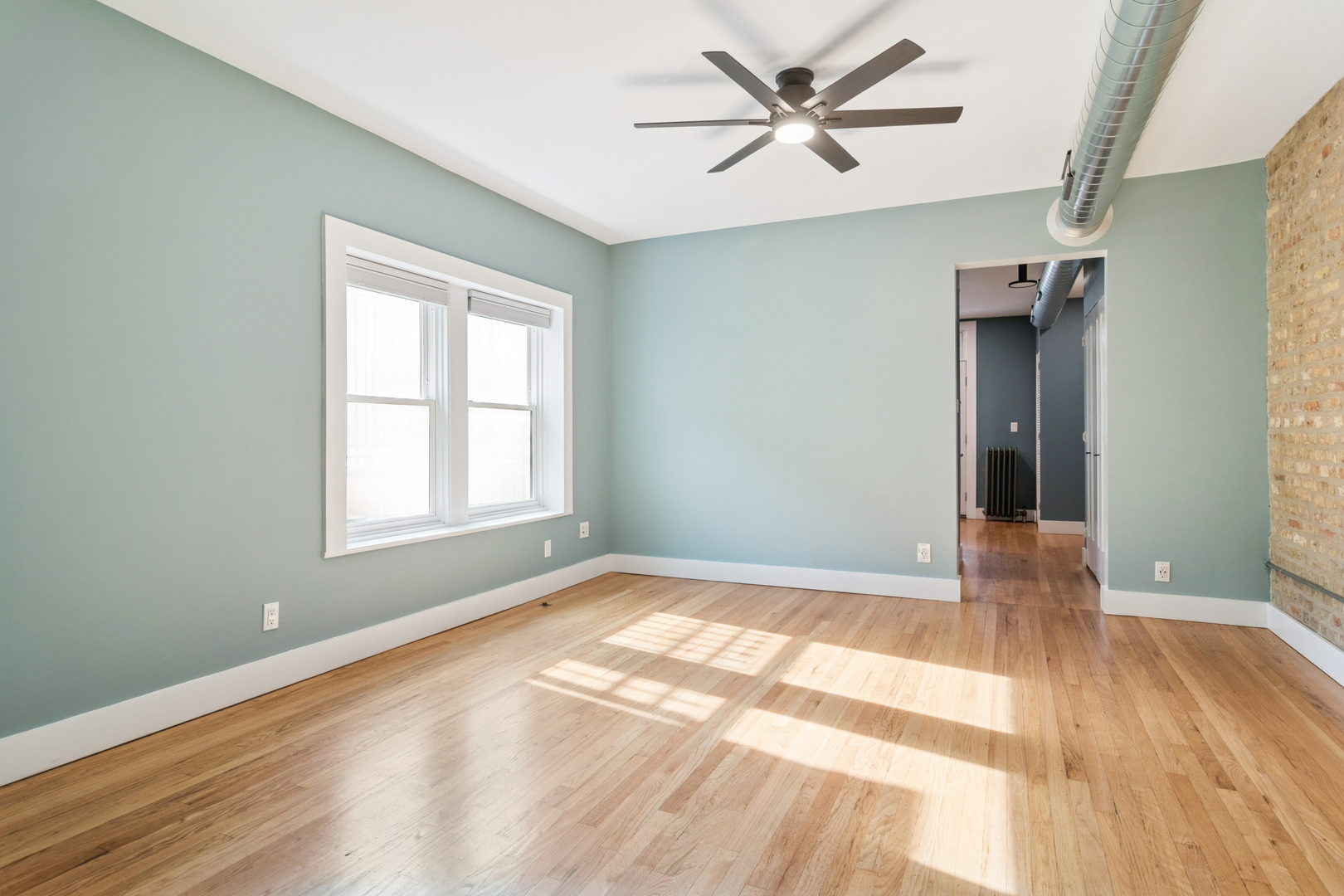 6232 North Broadway, Unit 2 Chicago, IL 60660 - Photo 14 of 23 wooden floor in an empty room with a window