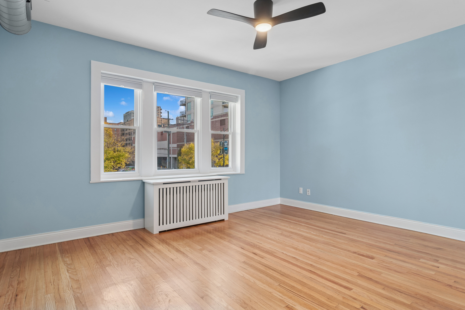 6232 North Broadway, Unit 2 Chicago, IL 60660 - Photo 15 of 23 a view of an empty room with wooden floor and a window