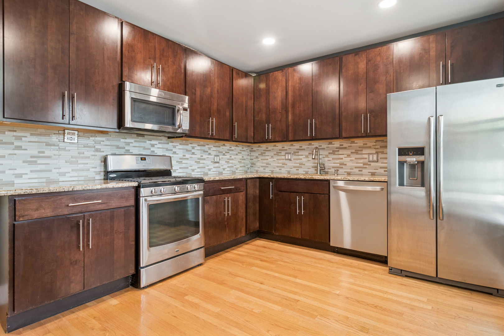 6232 North Broadway, Unit 2 Chicago, IL 60660 - Photo 2 of 23 a kitchen with stainless steel appliances granite countertop a stove a sink dishwasher a refrigerator and a microwave oven