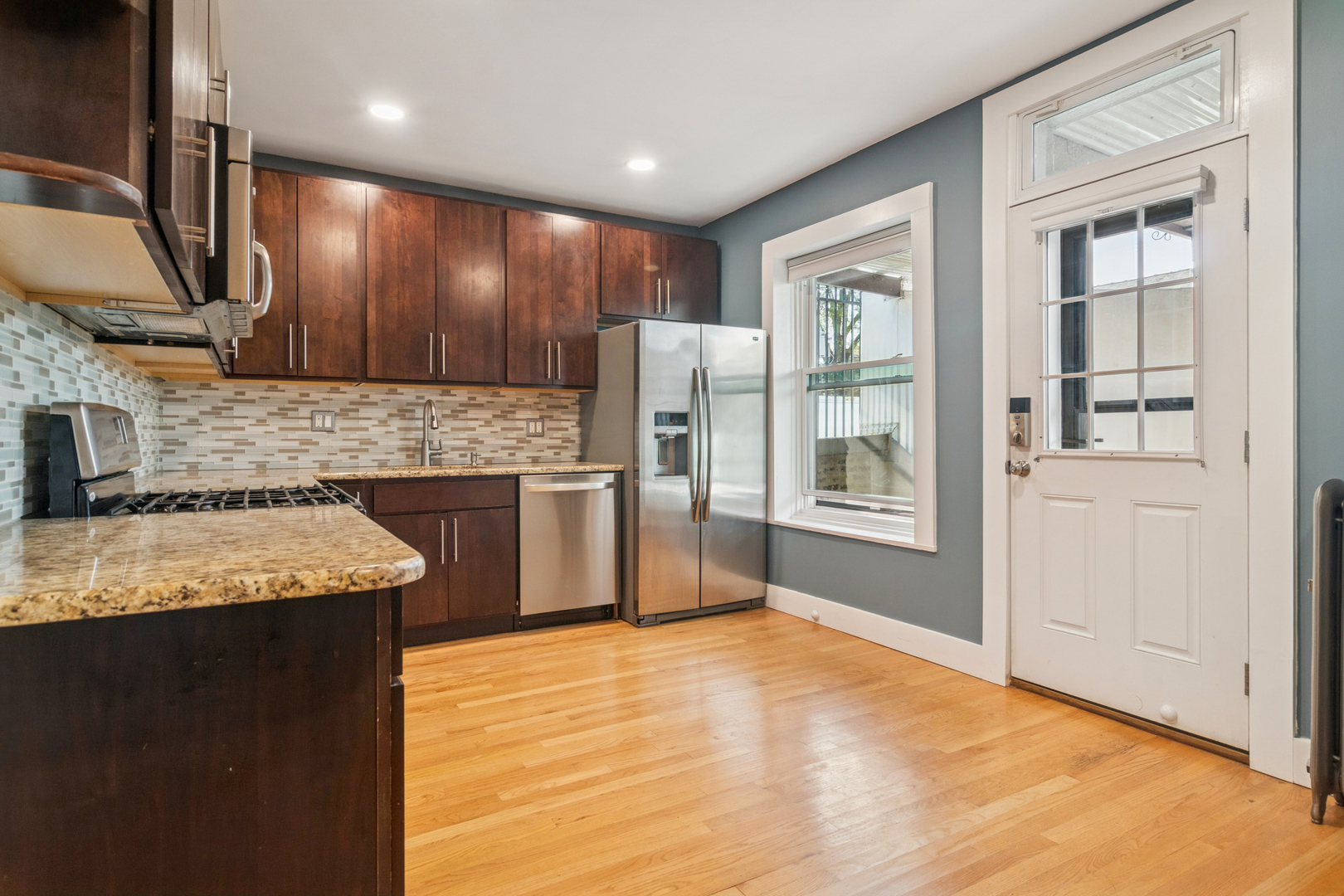 6232 North Broadway, Unit 2 Chicago, IL 60660 - Photo 7 of 23 a kitchen with stainless steel appliances granite countertop a sink stove and refrigerator