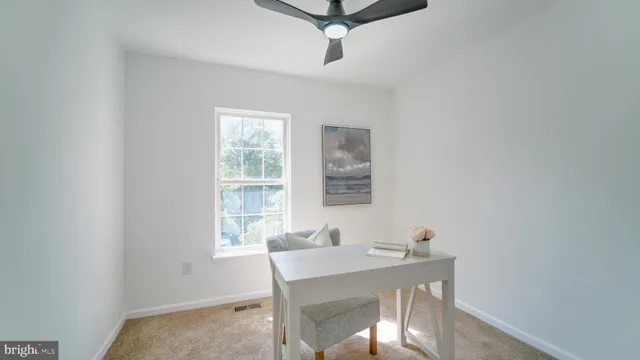 a view of a workspace with furniture and window