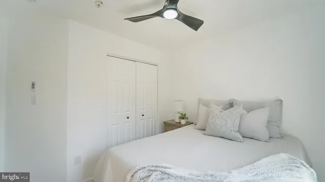 a bedroom with a bed and a ceiling fan