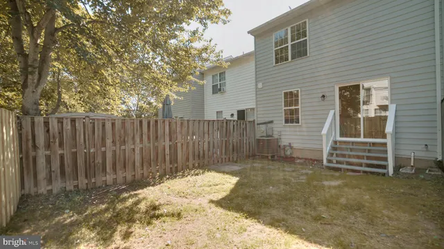 a view of a yard with wooden fence
