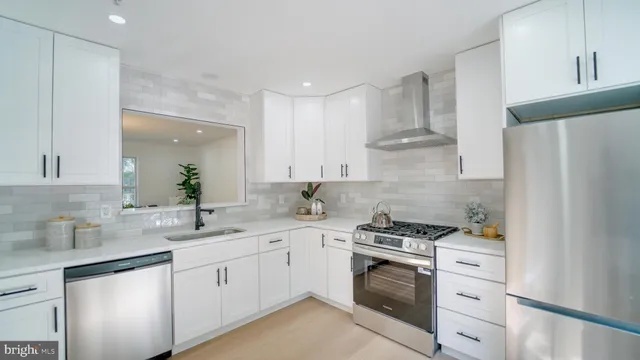 a kitchen with white cabinets and white appliances