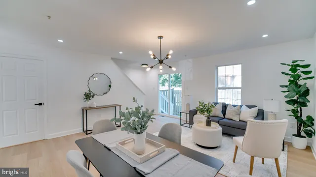 a living room with furniture a potted plant and a chandelier