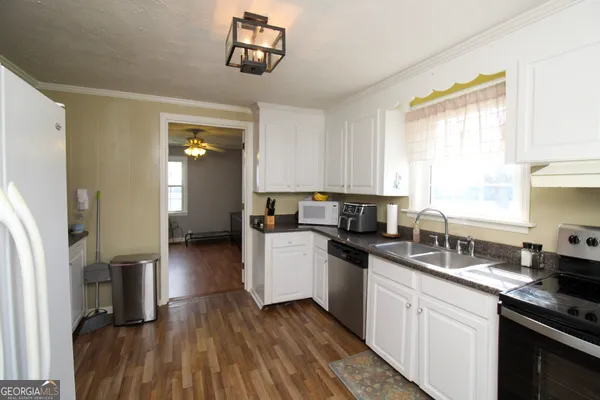 a kitchen with a sink cabinets stainless steel appliances and a window