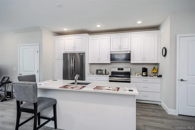 a kitchen with kitchen island white cabinets and stainless steel appliances