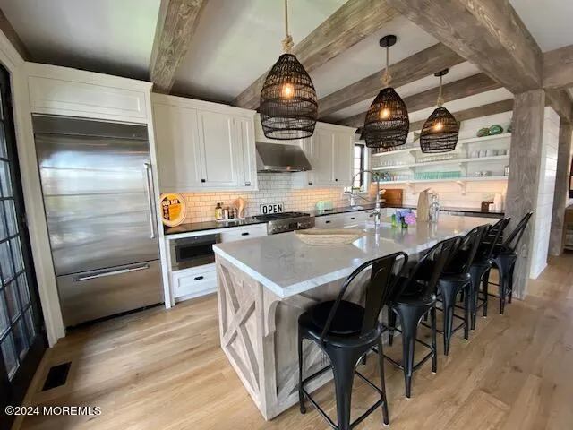 a kitchen with stainless steel appliances granite countertop a sink and white cabinets