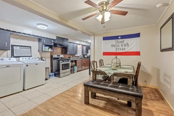a living room with stainless steel appliances furniture and a kitchen view
