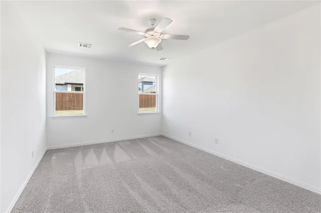an empty room with a window and a fan