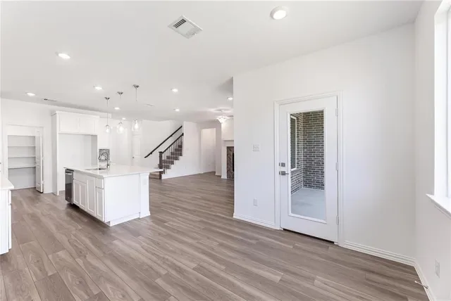 a view of a hallway with wooden floor and staircase