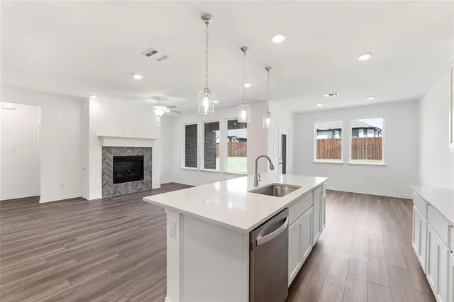 a kitchen with a sink chandelier and wooden floor