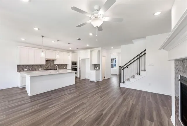 a open kitchen with kitchen island white cabinets and stainless steel appliances