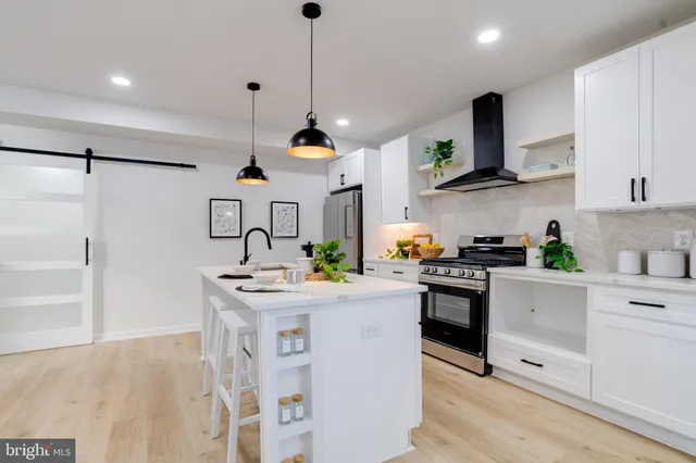 a kitchen with stainless steel appliances kitchen island granite countertop a sink a stove and cabinets