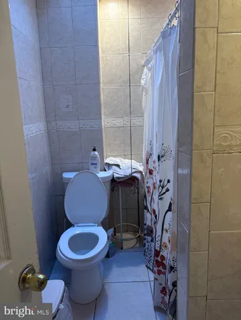 a bathroom with a toilet and shower curtain