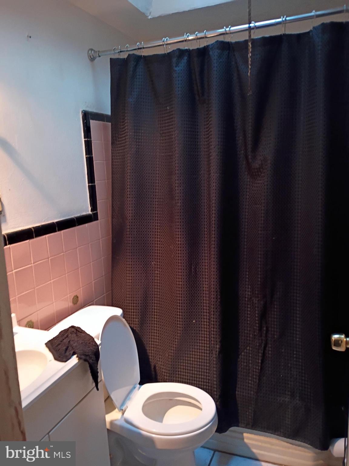 7555 Sherwood Road Philadelphia, PA 19151 - Photo 7 of 10 a bathroom with a toilet and a shower curtain