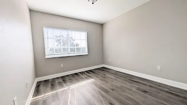 a view of a room with wooden floor and window