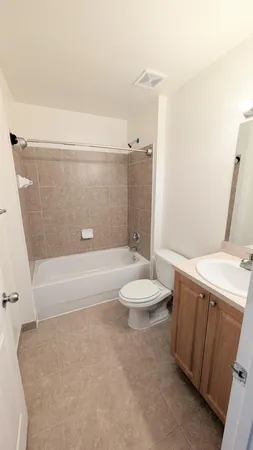 a bathroom with a granite countertop sink a toilet a mirror and bathtub