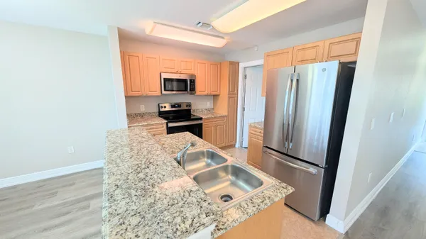 a kitchen with stainless steel appliances granite countertop a refrigerator and a stove top oven