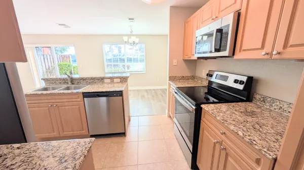 a kitchen with stainless steel appliances granite countertop a sink stove and cabinets