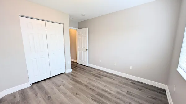a view of an empty room with wooden floor