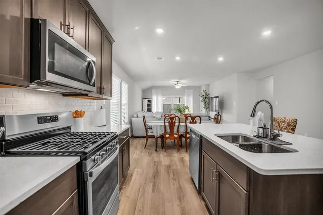 a kitchen with stainless steel appliances granite countertop a sink stove and microwave