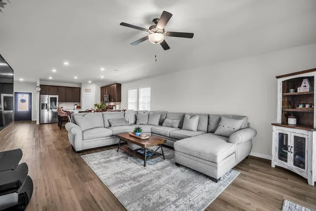 a living room with furniture and view of kitchen