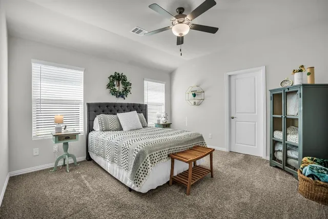 a spacious bedroom with a bed and a chandelier