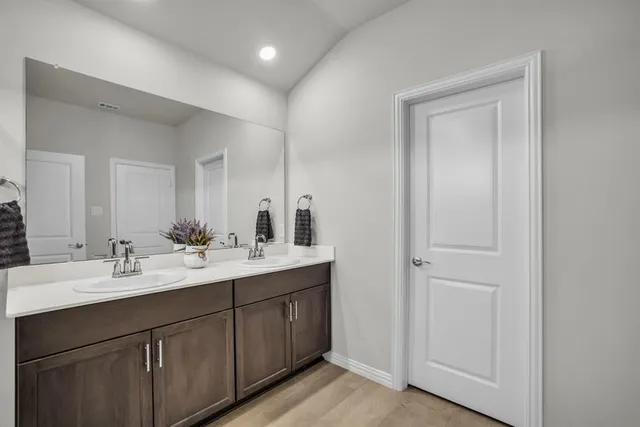 a bathroom with a double vanity sink and mirror
