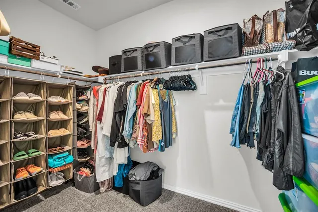 a view of walk in closet with clothes and shoes