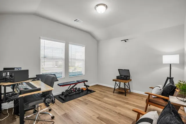 a view of a workspace with furniture and wooden floor