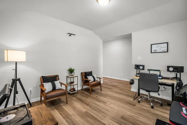 a kitchen with stainless steel appliances a microwave a stove a sink dishwasher a refrigerator and a dining table with wooden floor