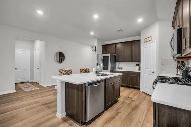 a kitchen with stainless steel appliances granite countertop a sink stove and refrigerator